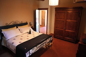 Une chambre à coucher avec un lit, une table de chevet, une lampe et une armoire.