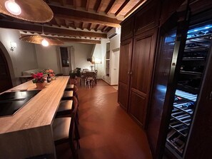 A kitchen with a central island, wooden cabinets, and a built-in oven. - Private Tuscan estate surrounded by vineyards   (Toscana)