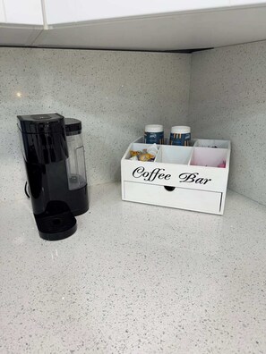 A coffee maker and a coffee bar with various coffee pods and containers. - Hale Haven - Luxury Stay in the Heart of Tampa! (Tampa)