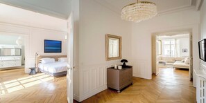 A spacious room with a bed, a dresser, a mirror, and a television. - Elegant 220m² Abode In Grands Boulevards: Expansive Living & Refined Interiors (Paris)