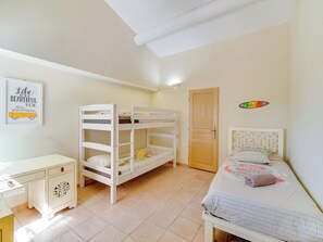 A room with bunk beds, a desk, a door, and a wall decoration. - Le Petit Mas - Piscine - Golf de Pont Royal (Mallemort)