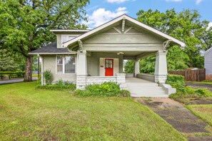 A two-story house with a red door, a covered porch, and a well-maintained lawn. - Spacious 5BR Home in Meridian (Meridian)