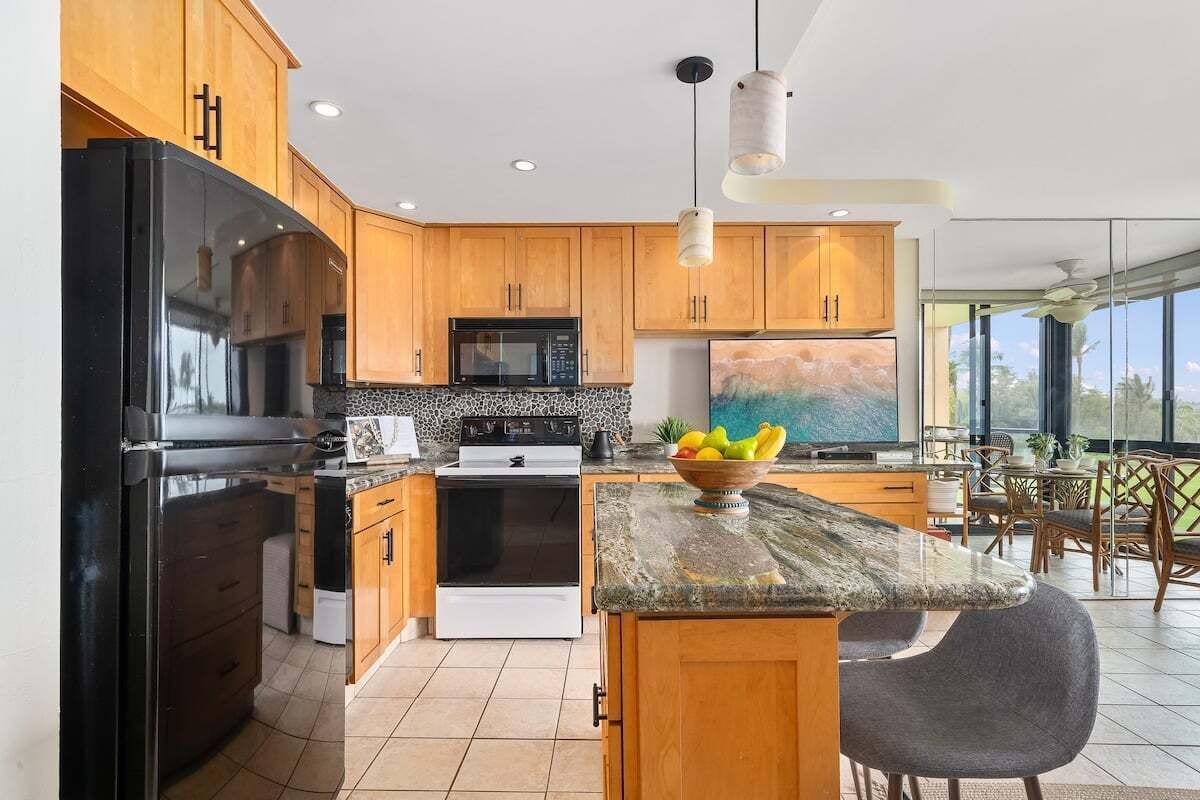 A modern kitchen with wooden cabinets, a black refrigerator, a stove, and a dining area with a table and chairs.