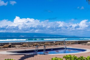 A pool area with lounge chairs and a view of the ocean. - Updated Oceanfront Whale Watching - Kulakane 211 (Napili-Honokowai)