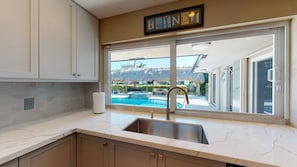 A kitchen with a large window, a sink, and cabinets. - Villa Bliss (Fort Lauderdale)