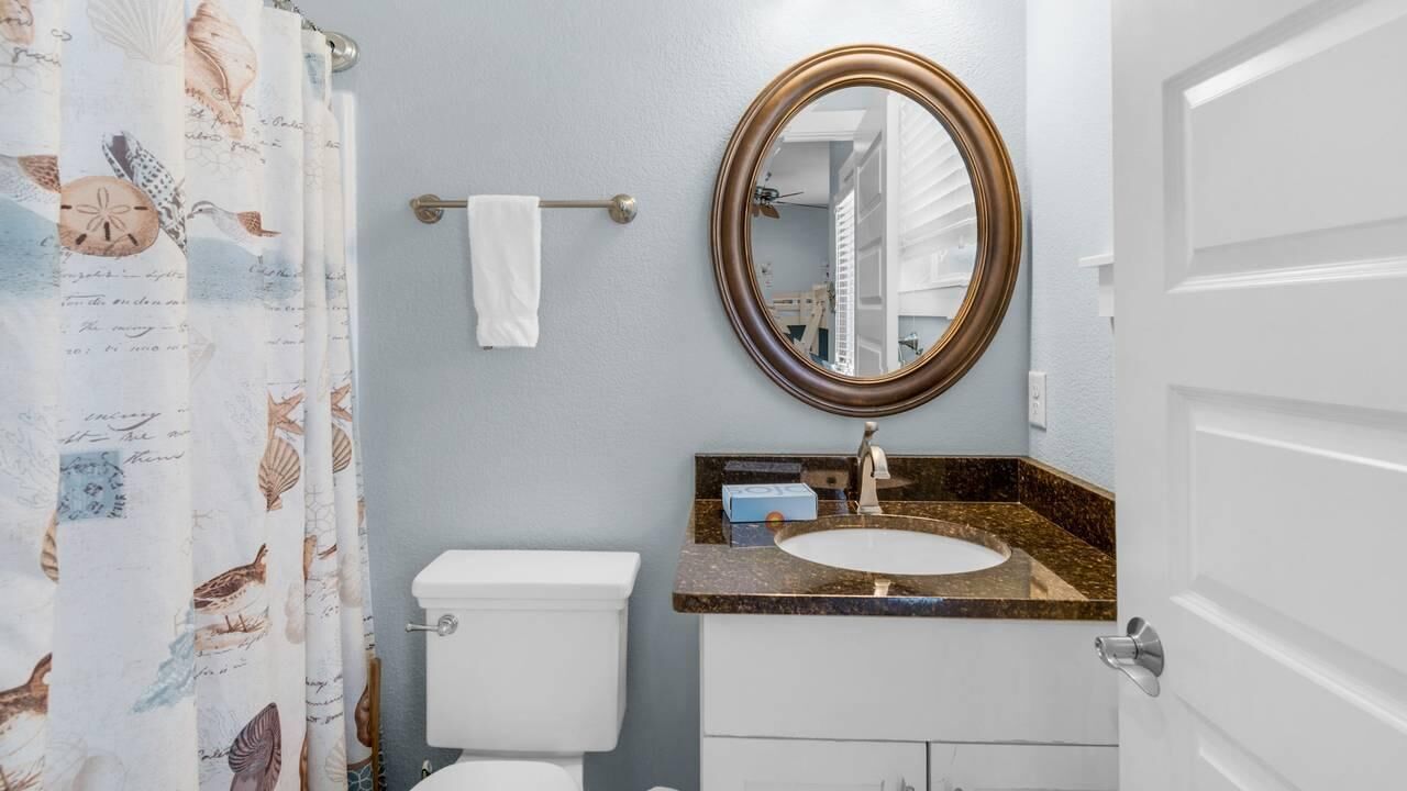 Une salle de bain avec des toilettes, un lavabo et un miroir.