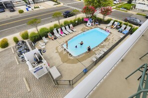 A rooftop pool area with lounge chairs, a pool, and a sign indicating a no diving zone.