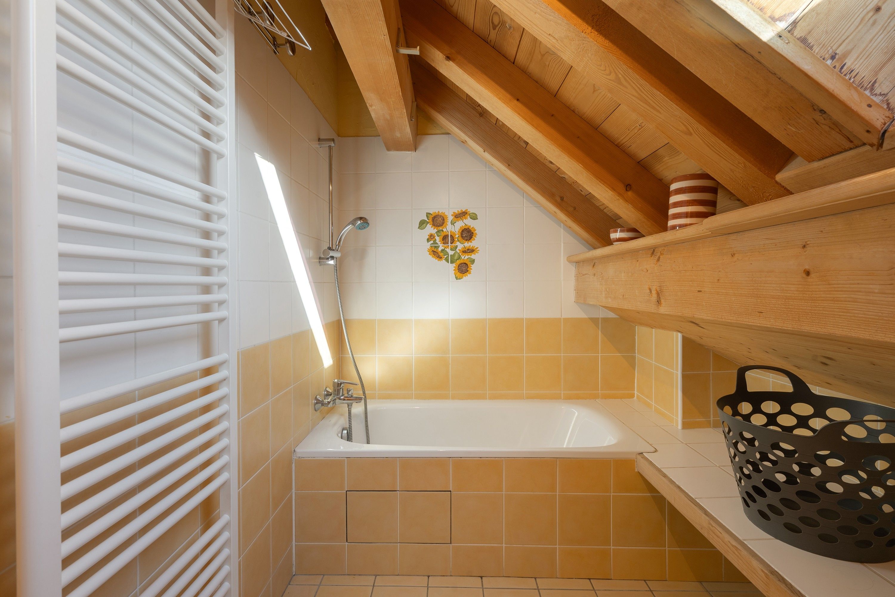 A bathroom with a bathtub, shower, and a towel rack.