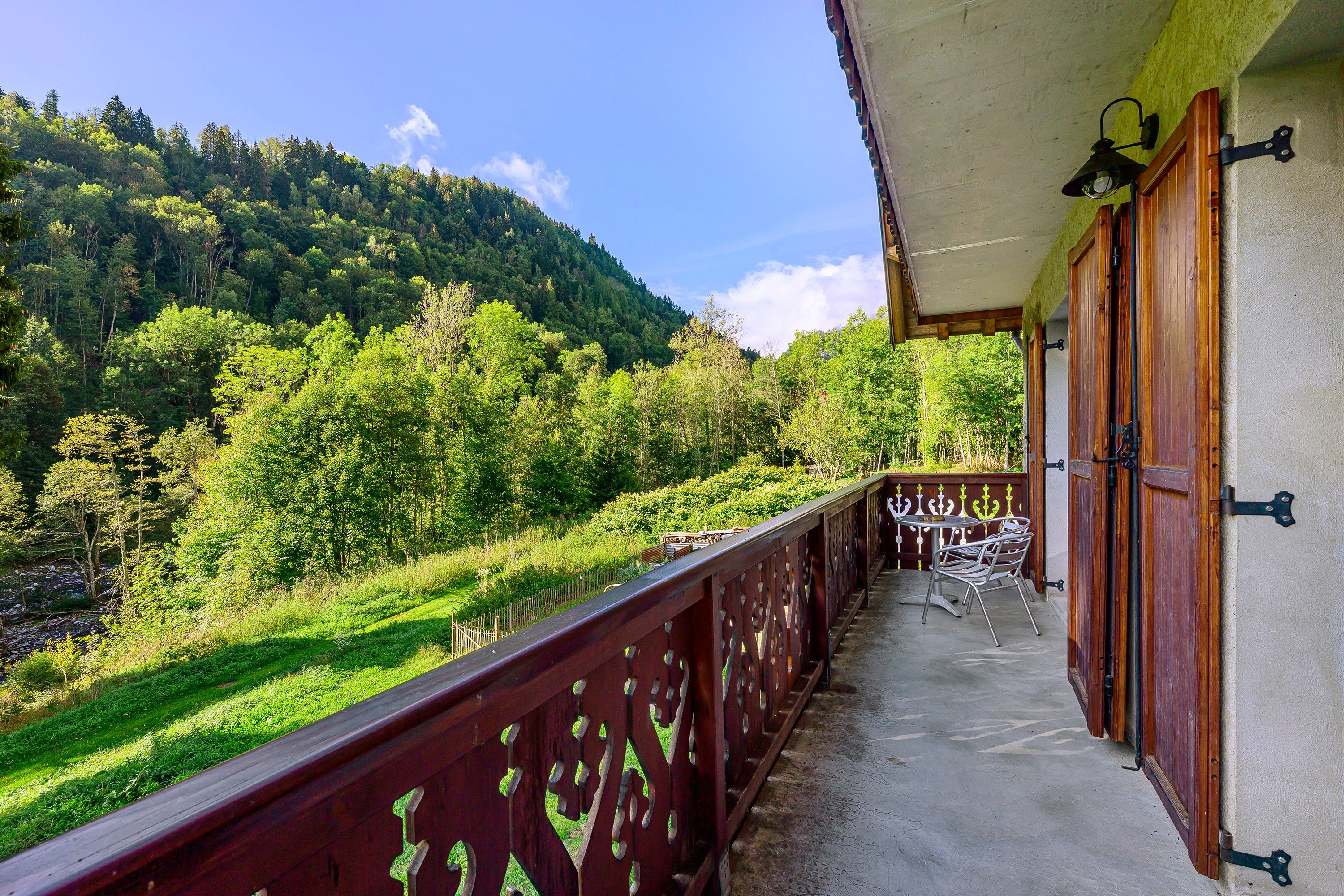 A balcony with a view of a forested hillside.