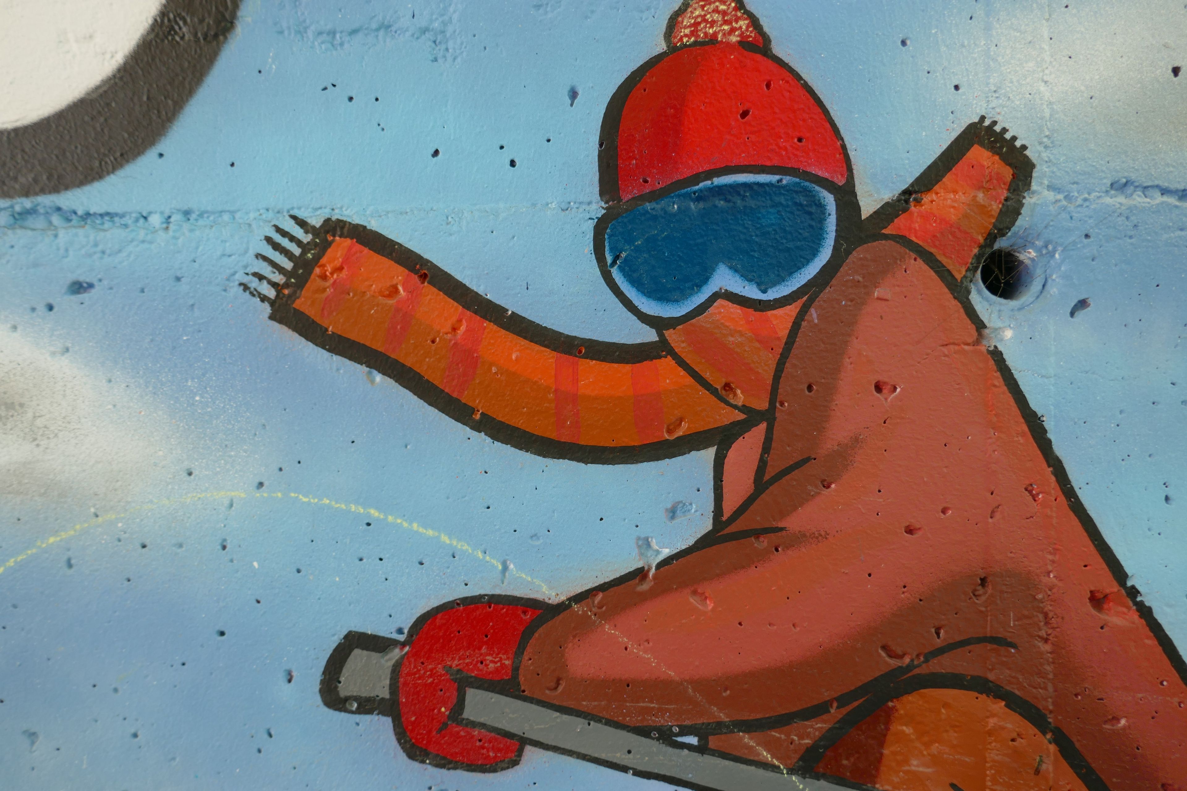 Iemand in een rode jas en skibril, mogelijk bezig met een activiteit buiten.