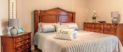 Ein Schlafzimmer mit einem hölzernen Bett, einem Nachttisch, einer Kommode und einer Lampe.