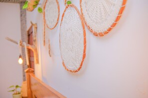 Pared decorada con elementos tejidos y barandilla de madera.