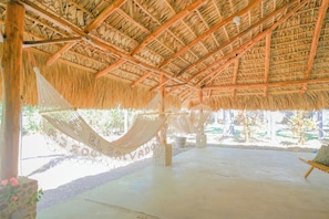 A thatched-roof structure with a hammock and a concrete floor. - Las Golondrinas KM-59 (Chiltiupan)