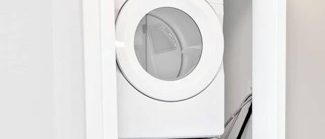 Un lavadero blanco con dos lavadoras Whirlpool apiladas.