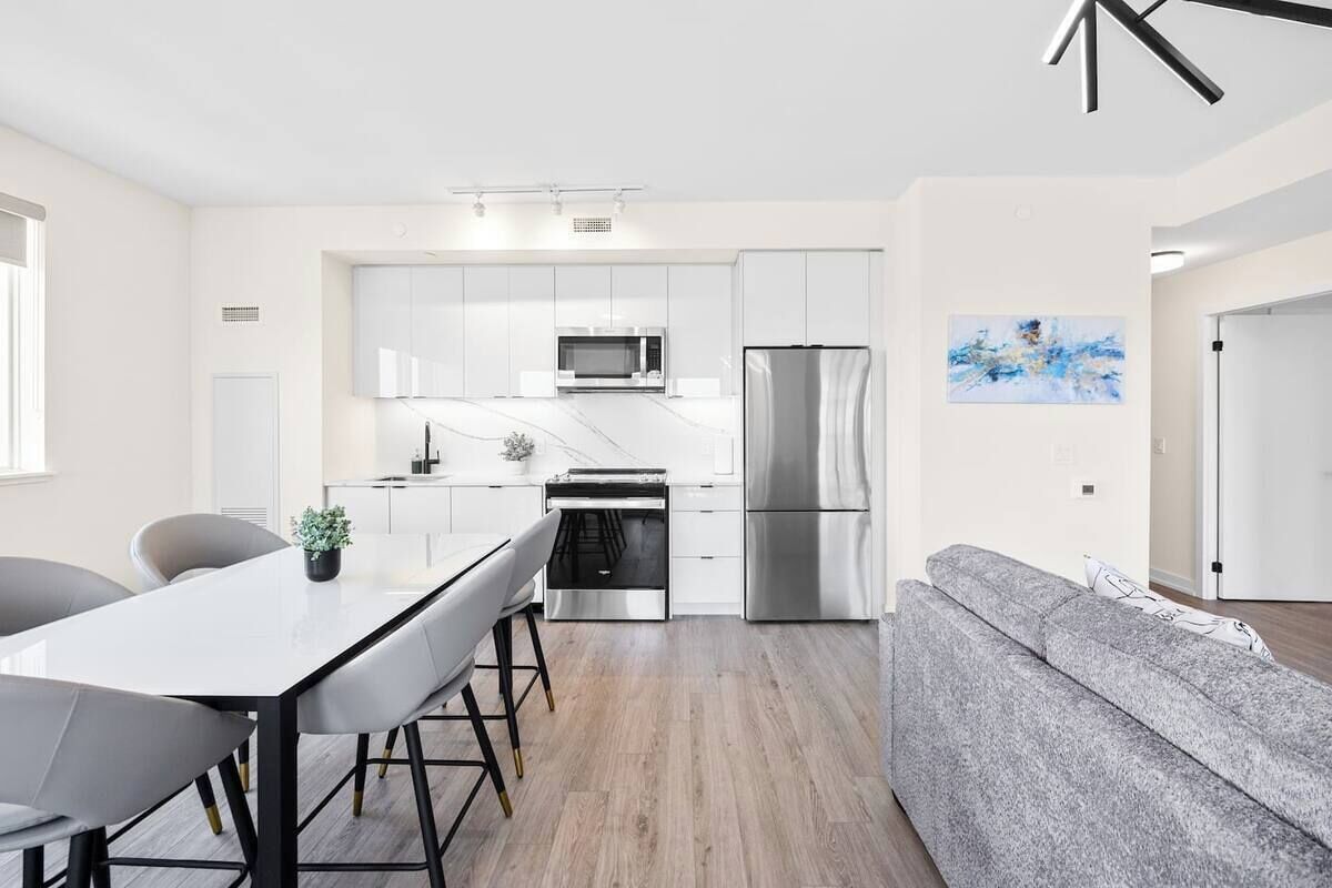 Une cuisine moderne avec un coin repas, un canapé et un tableau au mur.