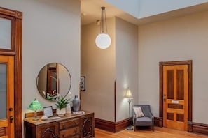 A room with a wooden dresser, a mirror, a lamp, and a door.