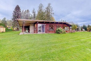 A single-story house with a covered porch, large windows, and a well-maintained lawn. - 3BR bay-front dog-friendly home, modern interior (Gig Harbor)