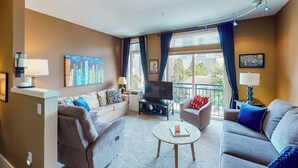 Een moderne woonkamer met een bank, een salontafel en een flatscreen televisie.