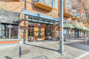 A building with a brick facade, large windows, and outdoor seating area.