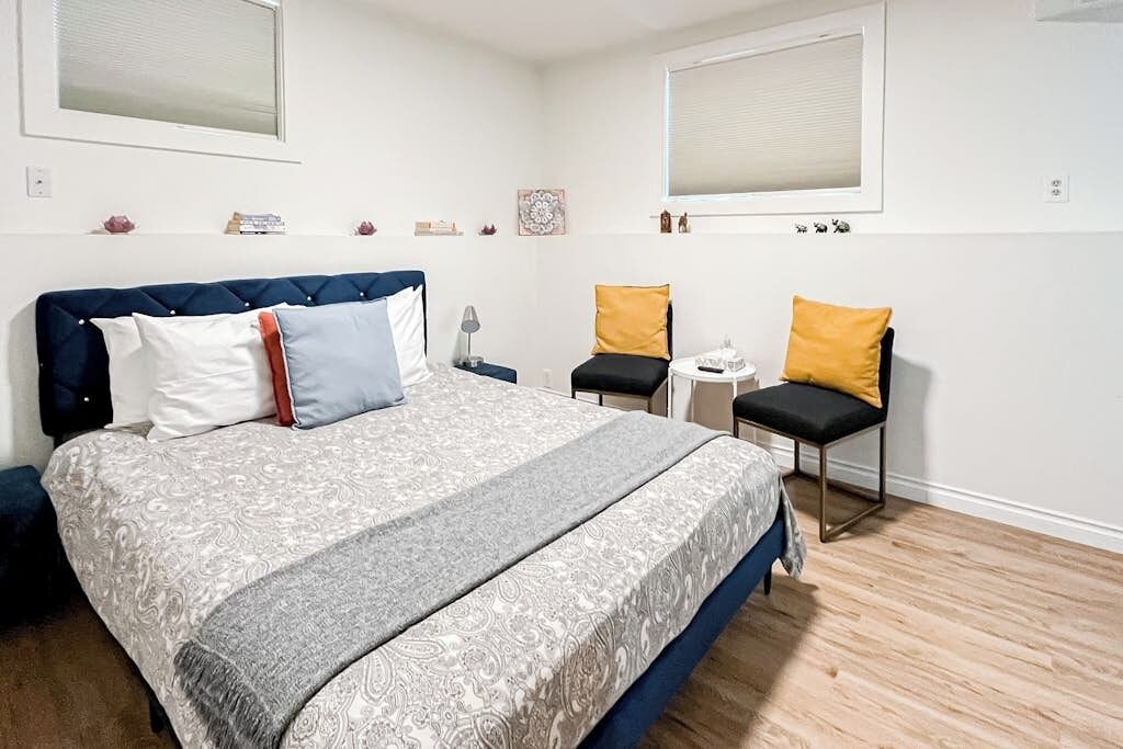 A bedroom with a bed, bedside tables, a chair, and a window.