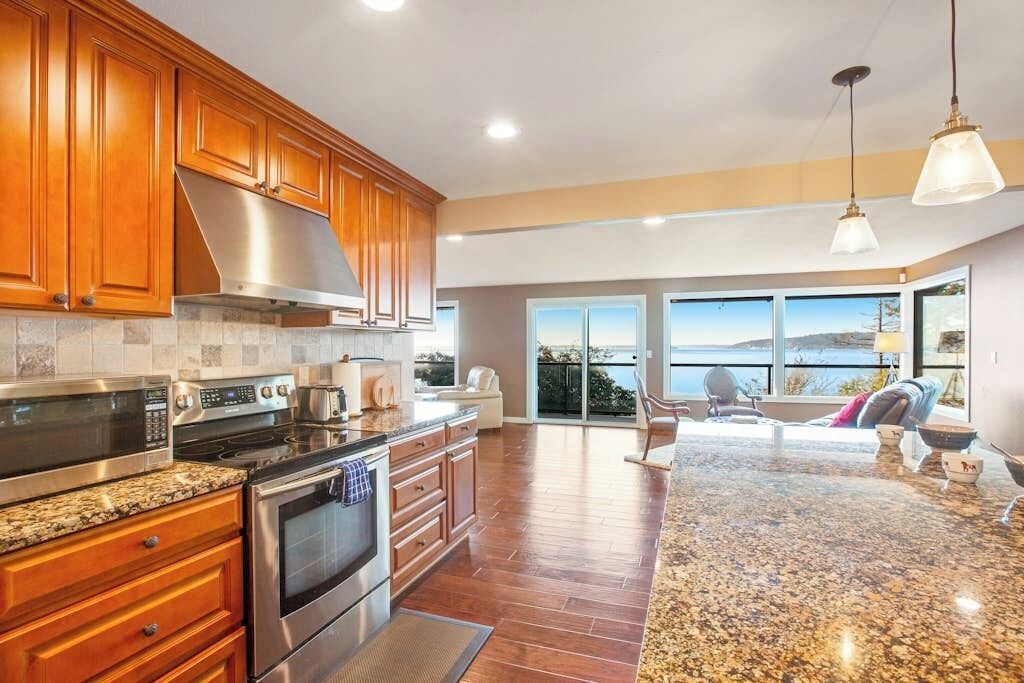 A modern kitchen with granite countertops, stainless steel appliances, and wooden cabinets.