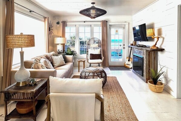 Een woonkamer met een bank, fauteuil, salontafel en een televisie.
