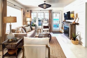 A living room with a sofa, armchair, coffee table, and a television. - Stunning 1BR Oceanview -Patio -Washer Dryer- Hottub-Firepit (Moclips)