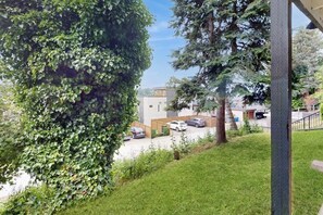 Ein Wohngebiet mit Rasen, einem geparkten Auto und einem Gebäude mit Flachdach.