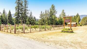 A rustic wooden sign for a mountain lodge with a clear sky and forested background.