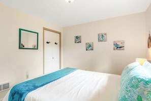 A bedroom with a bed, a door, and wall art. - Large 3BR Bayview Dog Friendly - Fireplace (Camano Island)
