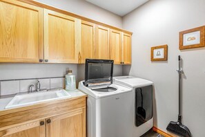 A laundry area with a washing machine, a dryer, and a sink. - Lakefront views with hot tub, firepit, & deck (Sedro-Woolley)