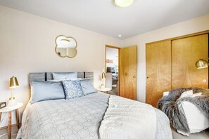 A bedroom with a bed, bedside lamps, a mirror, a wardrobe, and a fur throw. - ski-in and out 3BR with mountain views & fireplace (Snoqualmie Pass)