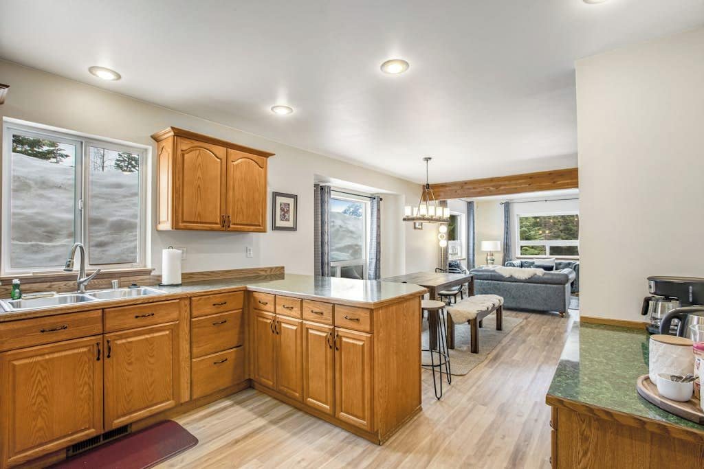 A spacious kitchen with wooden cabinets, a large island, and a dining area with a sofa and chairs.