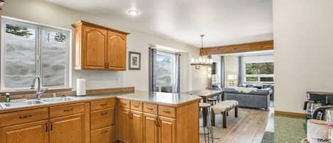 A spacious kitchen with wooden cabinets, a large island, and a dining area with a sofa and chairs.