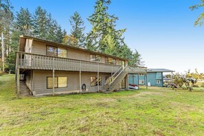 A two-story house with a balcony, a garage, and a yard. - 3BR Waterview - Fireplace - Balcony (Hansville)