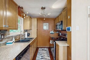 A compact kitchen with wooden cabinets, a built-in microwave, and a dishwasher. - 2 BR charming cotttage, pet-friendly, near Seattle (Seattle)