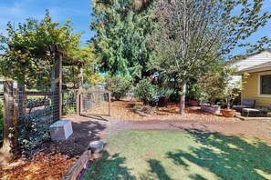 A fenced backyard with a wooden pergola, a variety of trees, and a well-maintained lawn. - 2 BR charming cotttage, pet-friendly, near Seattle (Seattle)