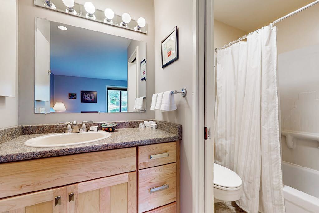 Un baño con lavabo, espejo y cortina de ducha.