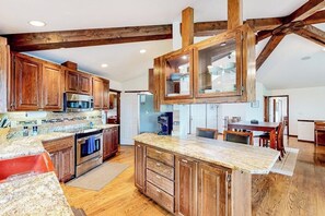 A kitchen with wooden cabinets, granite countertops, and a central island. - 2BR idyllic retreat with a hot & grill - dogs ok (Port Angeles)