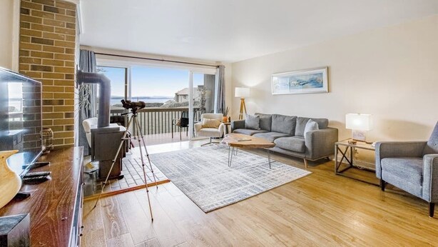 A modern living room with a balcony, a television, a sofa, and a coffee table.