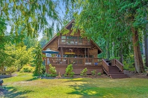 A cabin with a balcony, surrounded by trees. - 4BR charming lakeside home with beach access (Olympia)