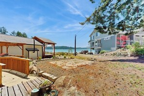 Een pand aan het water met een houten terras, een overdekte patio en uitzicht op het water.