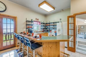 Eine Küche mit Bar, Holzausstattung und einer Uhr an der Wand.
