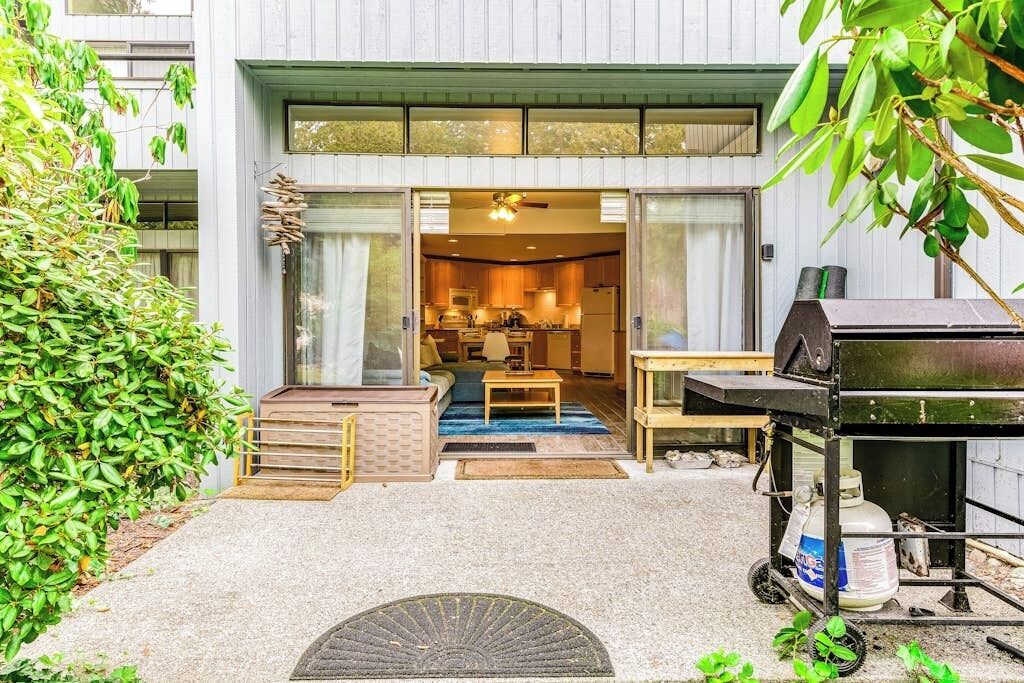 Une maison moderne dotée d’une grande porte-fenêtre coulissante qui donne sur un espace cuisine.