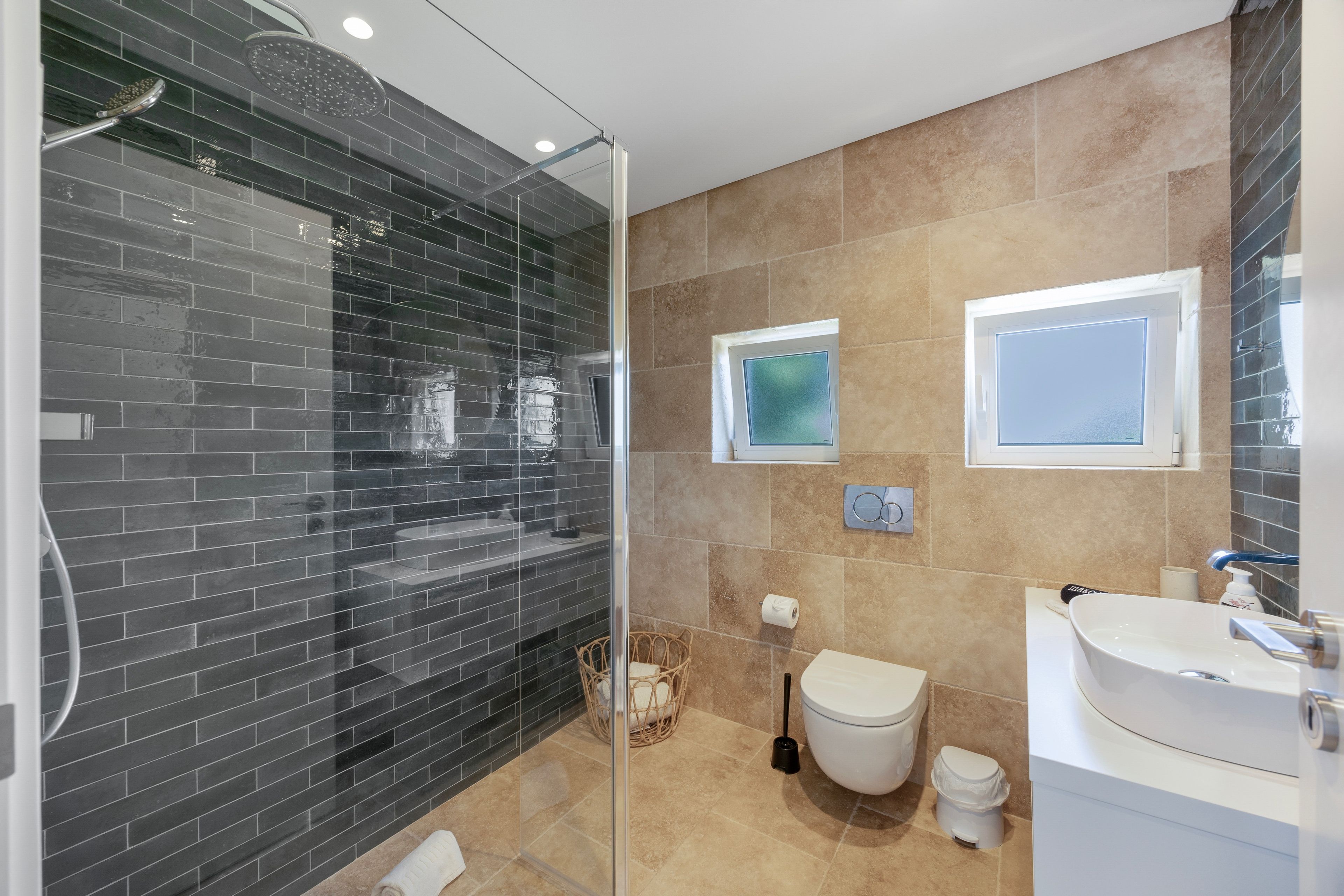 Une salle de bain moderne avec une douche à parois de verre, des toilettes et un lavabo.