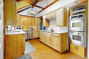 A kitchen with wooden cabinets, stainless steel appliances, and a built-in oven.