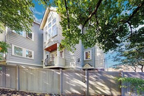 A two-story house with a balcony, a wooden fence, and a clear sky. - 3 BR townhome with gas fireplace close to downtown (Seattle)