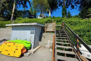 A private property with a small building, a wooden staircase, and a yellow and green kayak. - Sweeping 2BR Oceanfront - WoodStove - Balcony (Camano Island)