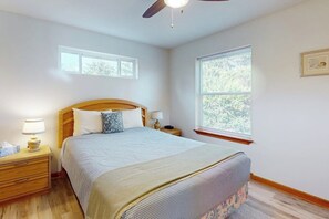 A bedroom with a bed, nightstands, a ceiling fan, and a window. - 2BR oceanview with spacious deck and wifi (Copalis Beach)