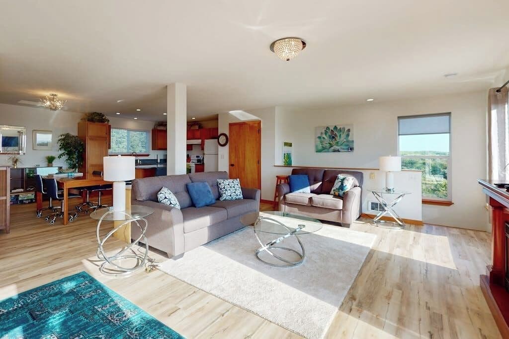 A spacious living area with a sofa, a coffee table, and a dining table.